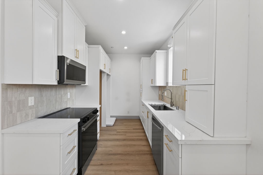ADU kitchen with quartz counters and shaker cabinetry